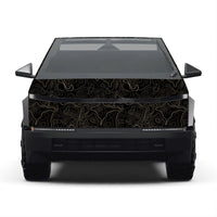 A front-facing view of a black vehicle with a custom vinyl wrap featuring a gold topographic contour line pattern on the hood, roof, and rear panel, set against a plain white background.