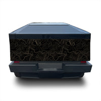 A rear view of a dark electric vehicle with a custom black vinyl wrap featuring a gold topographic contour line pattern on the back doors, shown against a white background.