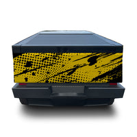 A rear view of a dark pickup truck bed featuring a bold yellow and black halftone dot and brushstroke graphic wrap on the side panel, shown against a plain white background.