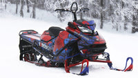 Snowmobile wrapped in red and blue printed vinyl, parked in snow