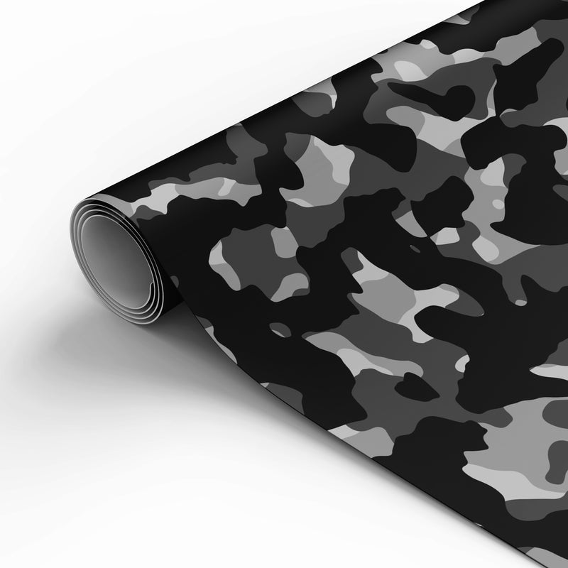 A roll of camouflage-patterned material, partially unrolled to show a black, gray, and white camo design on a clean white background.