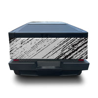 A rear view of a vehicle with a large black and white abstract brushstroke graphic wrap on the side panel, set against a plain white background.